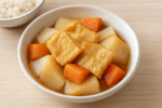 大根や人参などの野菜と一緒に煮込まれた、味がしみて美味しそうな油揚げの煮物の盛り付け写真